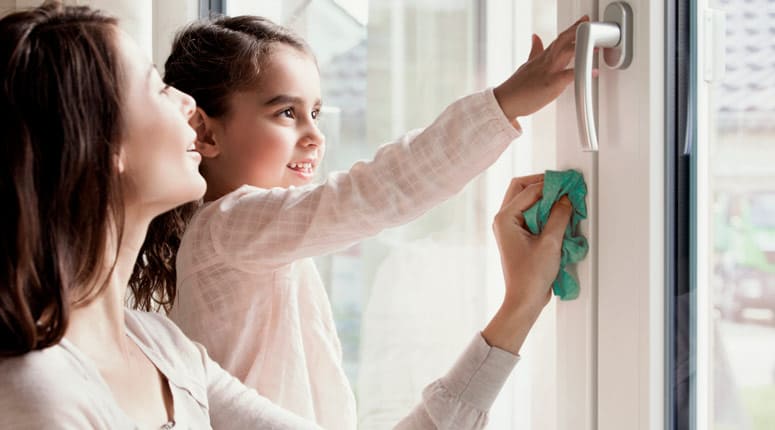 Persona limpiando fácilmente una ventana de PVC blanca Starwin.